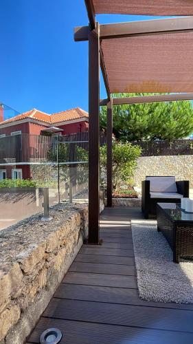 a wooden deck with a bench and a pavilion at Confluentia H&A - Luxury XIII Century Loft House in Coimbra