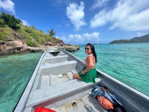 a woman sitting on the front of a boat in the water at Inspire Country House BY JR in Providencia