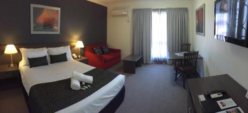 a hotel room with a bed and a red couch at Hunts Hotel Liverpool in Liverpool
