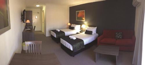 a hotel room with two beds and a chair at Hunts Hotel Liverpool in Liverpool