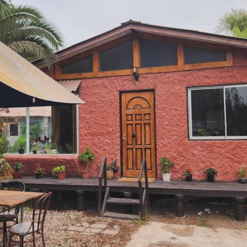 een rood bakstenen huis met een houten deur bij Cabañas Tronco viejo in La Serena