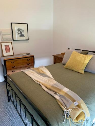 a bedroom with a bed and a wooden dresser at Sundays in Middleton