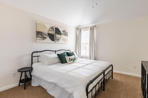 a bedroom with a large bed with white sheets and a window at Spacious & Fenced 5-BR Family Home Near Peter Jenkins Trail in Spring Hill