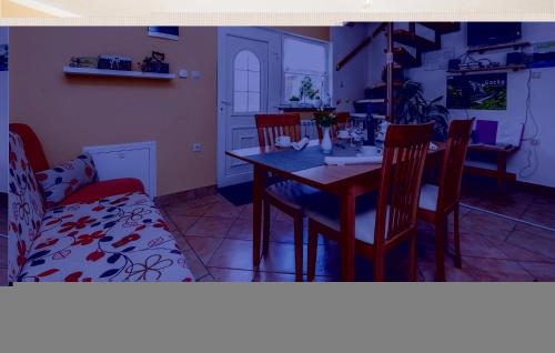 a dining room with a table and chairs and a couch at Nice Home In Licko Lesce With Wifi in Ličko Lešće