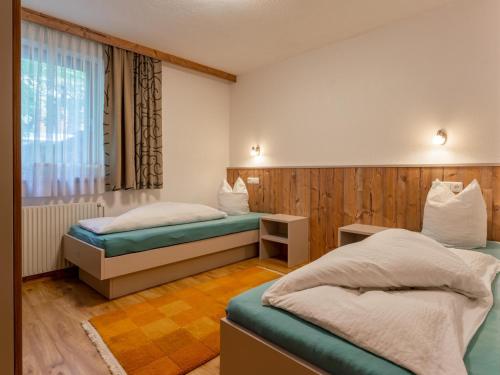 a hotel room with two beds and a window at Chalet Holdernach in Kappl