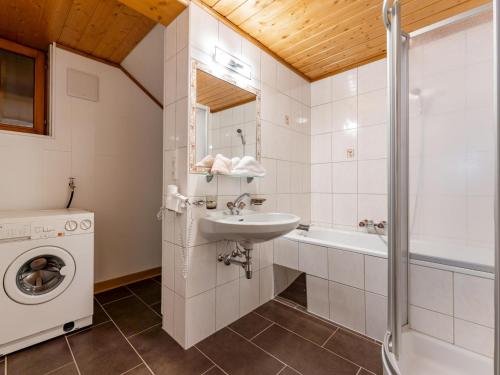 a bathroom with a sink and a washing machine at Chalet Holdernach in Kappl