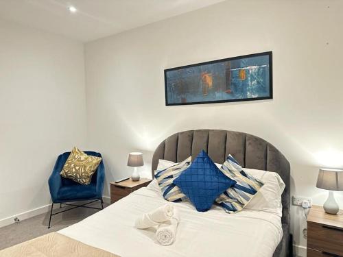 a bedroom with a bed and a blue chair at New Deluxe Birmingham City Centre Apartment 3 Bed in Birmingham