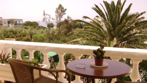 a table and chairs on a balcony with a palm tree at Irene Villa in Ierápetra