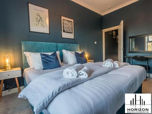 Un pat sau paturi într-o cameră la The Penthouse - Cosy Central Apartment - Free Parking