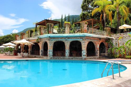 une grande piscine en face d'une maison dans l'établissement Mama Chuy Hotel & Villas, à San Juan Cosalá