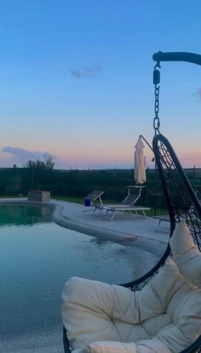 a swimming pool with a swing next to the water at Dimora Toscana in Treggiaia