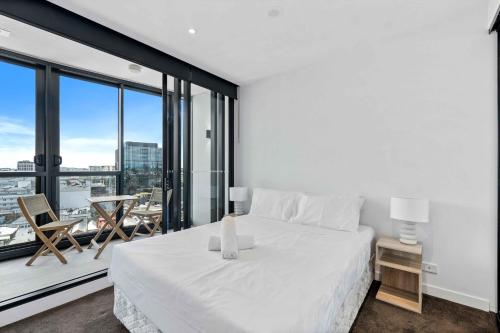 una camera da letto con un letto bianco e una grande finestra di Modern 1BR Apt with Gym Pool & Wifi a Brisbane