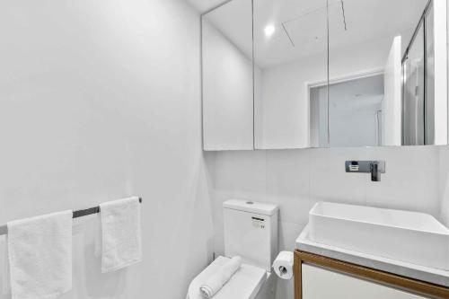un bagno bianco con lavandino e WC di Modern 1BR Apt with Gym Pool & Wifi a Brisbane