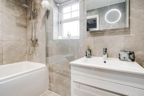 a bathroom with a white sink and a shower at Modern Warm 4 Bedroom House in Kirkby
