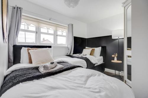 a bedroom with two beds with a dog laying on the bed at Modern Warm 4 Bedroom House in Kirkby