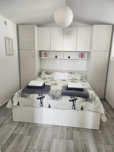 a white bedroom with a large bed in it at Secluded fisherman's cottage Cove Prnjica, Pag - 12620 in Kolan