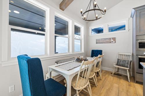 a dining room with a table and chairs and windows at New Mountain Bluebird - walk to lake, golf, and town - game rm - family friendly - sleeps 14 in Cascade