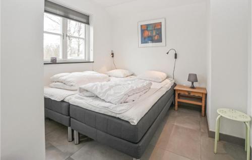 um quarto com uma cama com lençóis brancos e uma janela em Beautiful Home In Sydals With Sauna em Skovby