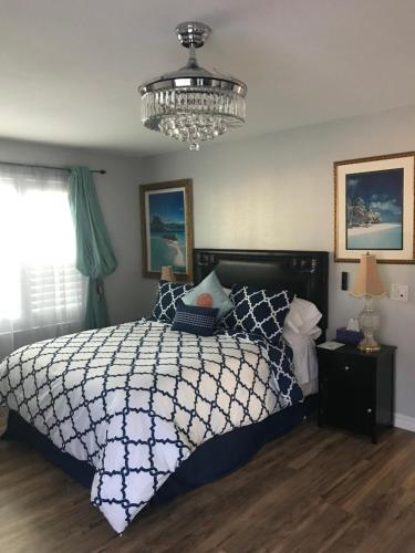 um quarto com uma cama e um lustre em Romantic Coastal Private Room em Oxnard