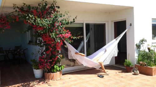 a white hammock on a patio with flowers at Casa Lagoa Verde in Esmoriz