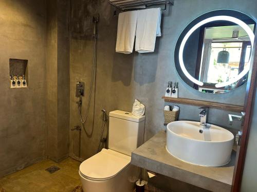 a bathroom with a sink and a toilet and a mirror at BK Beach Boutique Hotel - Hikkaduwa in Hikkaduwa