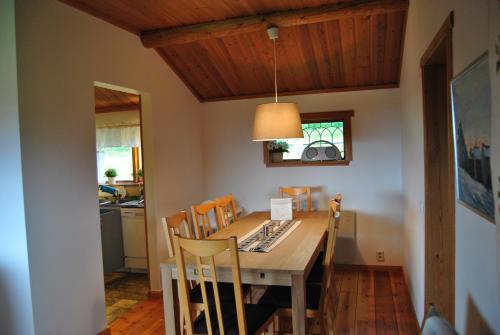 een eetkamer met een houten tafel en stoelen bij Orsastuguthyrning-Höglunda in Orsa
