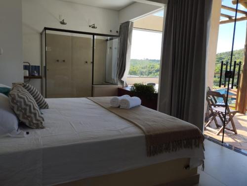 a bedroom with a large bed with towels on it at Chalé Jenipapo in Santana do Riacho