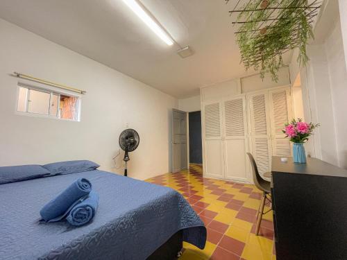 a bedroom with a blue bed and a desk and a fan at Casa encanto, Apartamento - Habitaciones, Laureles-América in Medellín