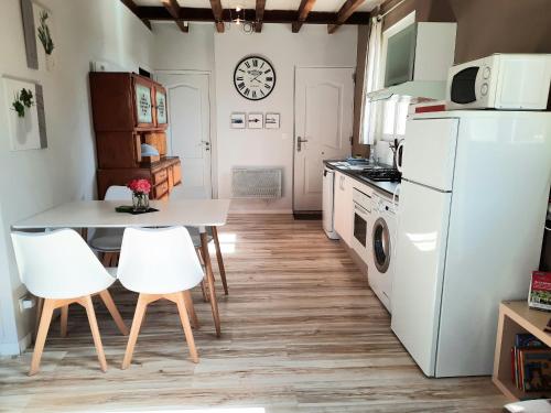 a kitchen with a table and white appliances at Gîte charmant 4 pers avec jardin privé, proche Saumur et bords de Loire, tout inclus - FR-1-622-5 in Brain-sur-Allonnes