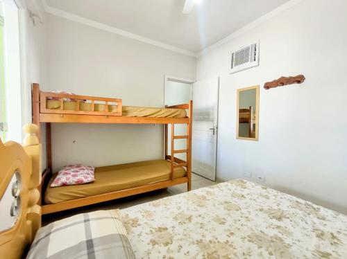 een slaapkamer met 2 stapelbedden en een bed bij casa com piscina in Ubatuba