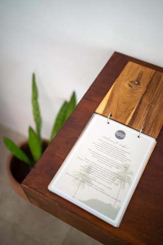a wooden table with a book on top of it at Suku Lifestyle Hotel & Villas in Selong Belanak