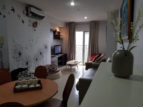 a living room with a table and a couch at Apartment Thamrin City mall 3 BR near Tanah abang in Jakarta
