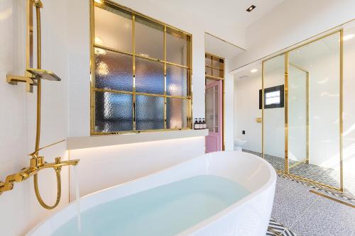 ein Bad mit einer Badewanne und einem Fenster in der Unterkunft Private Pool Villa with filled with stars in Ulsan