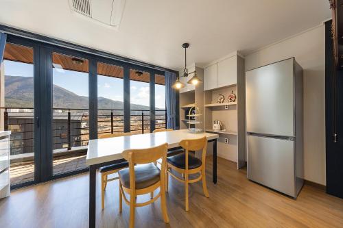 a kitchen with a table and chairs and a large window at Private Pool Villa with filled with stars in Ulsan