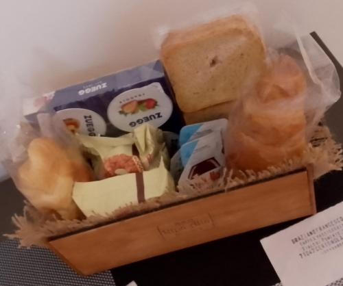 una scatola di alimenti con pane e altri prodotti alimentari di Ripa Alta Room's a Cerignola