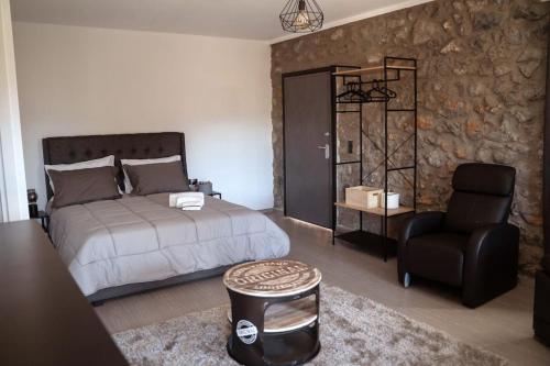 1 dormitorio con 1 cama y 1 silla negra en Triantos Guesthome Suite, en Tripolis