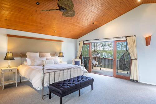 a bedroom with a large bed and a balcony at Riverside Ranch - oceanstays in Yamba