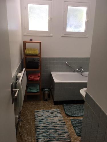 La salle de bains est pourvue d'une baignoire, d'un lavabo et de 2 fenêtres. dans l'établissement Belle Maison proche Disneyland, à Montévrain