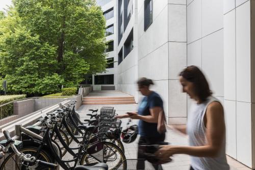 two people walking past a row of bikes at Crowne Plaza Canberra by IHG in Canberra