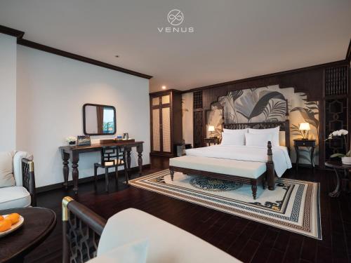 a bedroom with a bed and a table and a mirror at Venus Cruises Halong Bay in Ha Long