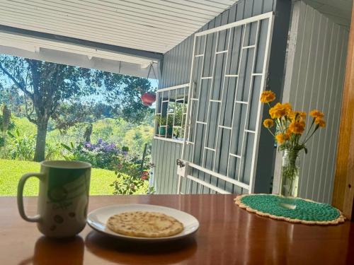 - une table avec une tasse de café et une assiette de nourriture dans l'établissement Casa de Campo, à Sabalito
