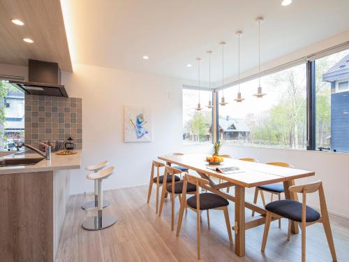 a kitchen and dining room with a wooden table and chairs at Olaf House in Niseko