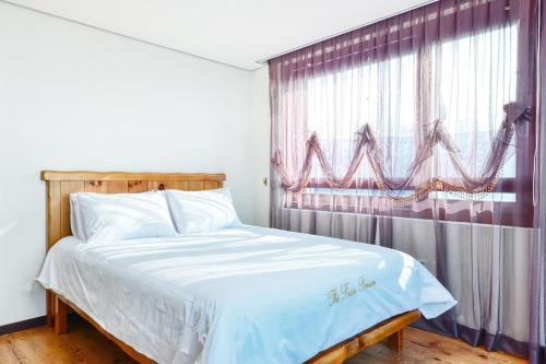 Ένα ή περισσότερα κρεβάτια σε δωμάτιο στο The Raon Pension