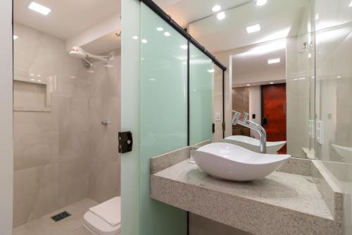 a bathroom with a sink and a toilet and a shower at Residencial Oliveiras - Apartamento 3 in Brasilia