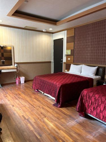 a hotel room with two beds with red sheets at Yosemite Hot Spring Resort in Baihe