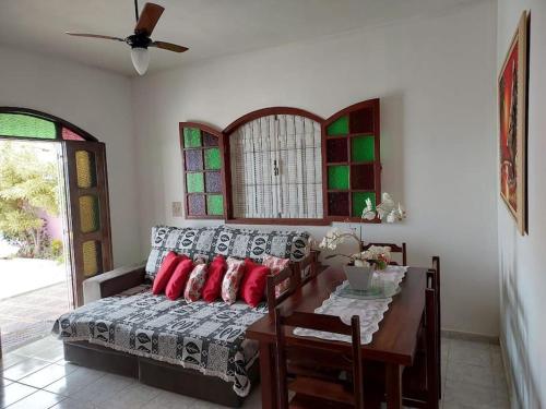 Schlafzimmer mit einem Bett, einem Tisch und einem Fenster in der Unterkunft Uma jóia em frente ao mar! in Piúma