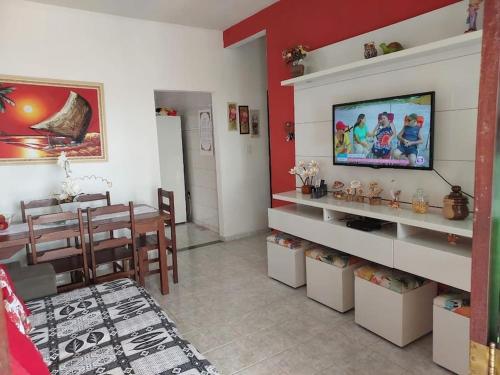 ein Wohnzimmer mit einem TV und einem Esszimmer in der Unterkunft Uma jóia em frente ao mar! in Piúma