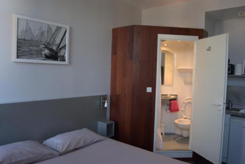 - une chambre avec un lit et une salle de bains avec des toilettes dans l'établissement Smartappart Cherbourg (la rose des vents), à Cherbourg en Cotentin