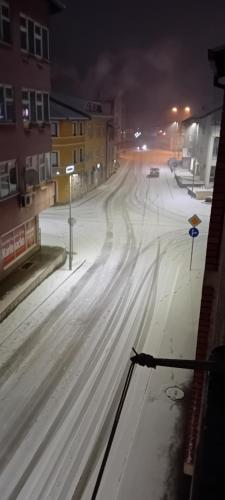 uma rua coberta de neve à noite com carros nela em Stan na Dan em Gornji Vakuf