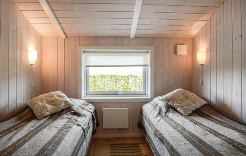 2 łóżka w małym pokoju z oknem w obiekcie Cozy Home In Haderslev With Sauna w mieście Flovt